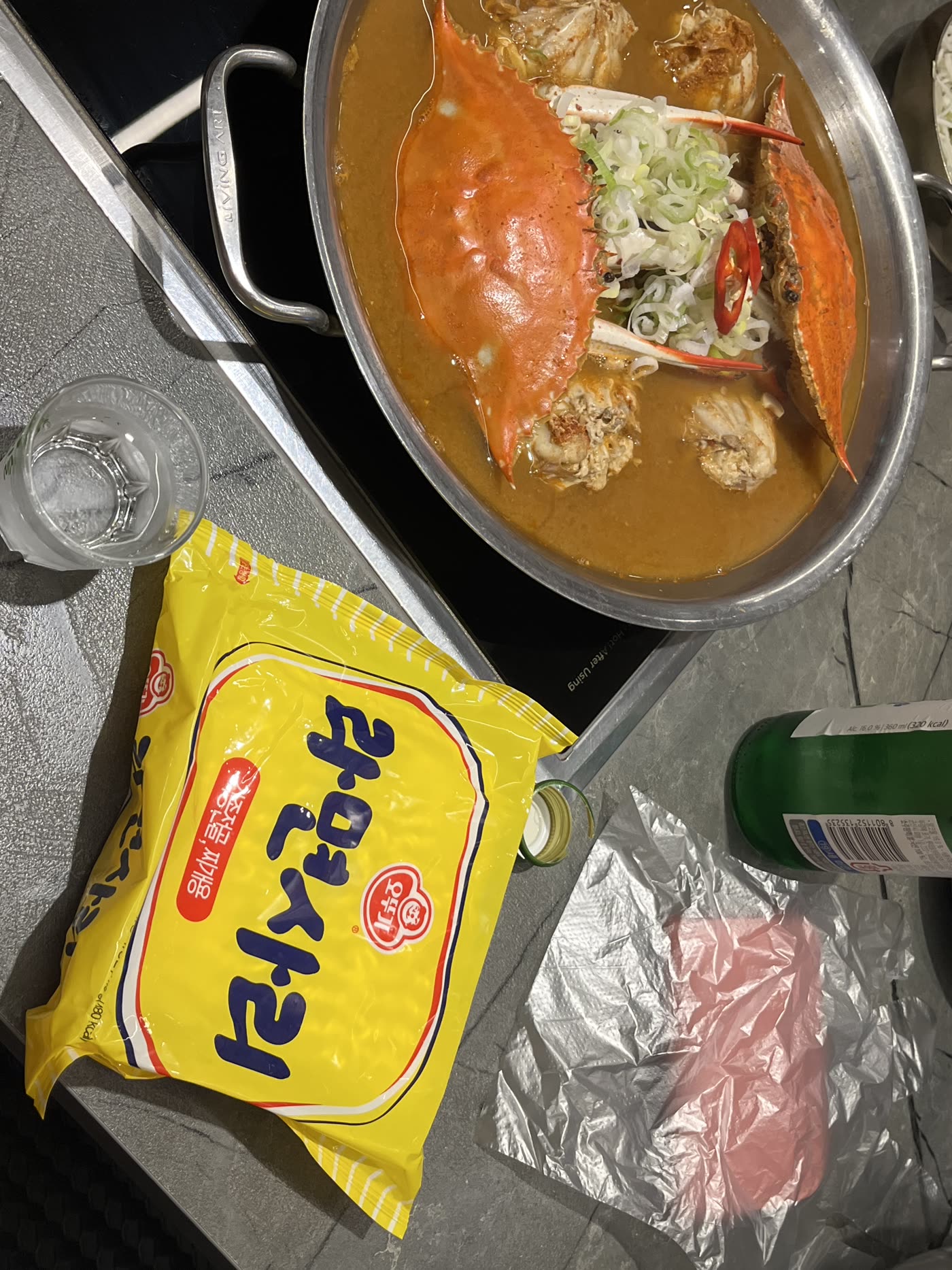 The stew arrives with a pack of ramyeon on the side