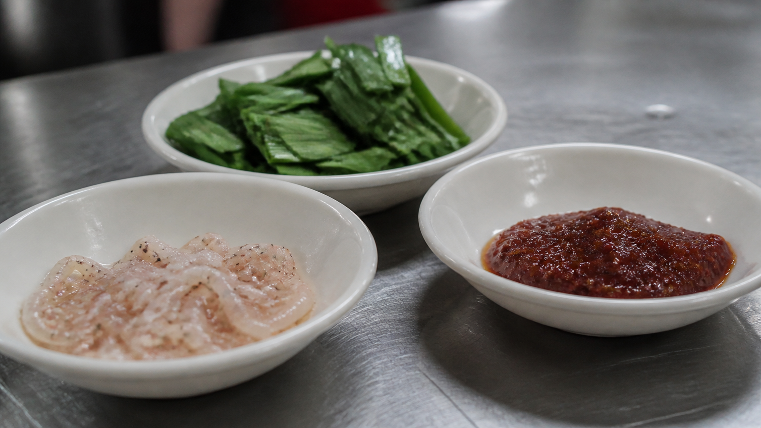 Salted shrimp, garlic chives, chilli paste. The bowl arrives plain because you season it yourself.