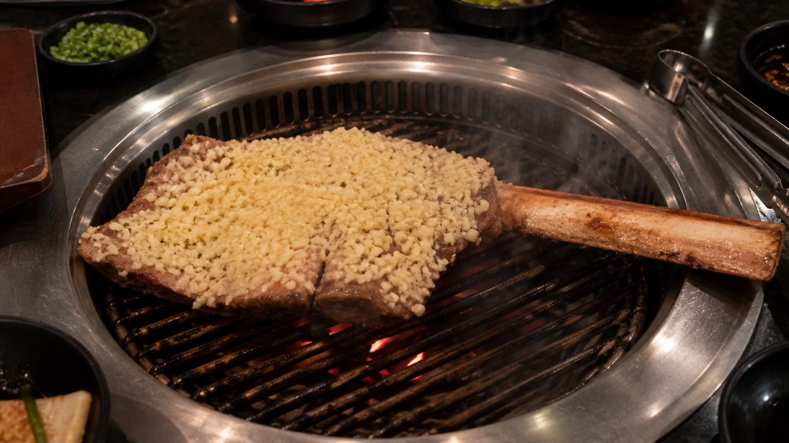 A butterflied bone-in rib under a drift of chopped garlic, cooked on residual charcoal heat. Illustrative image.