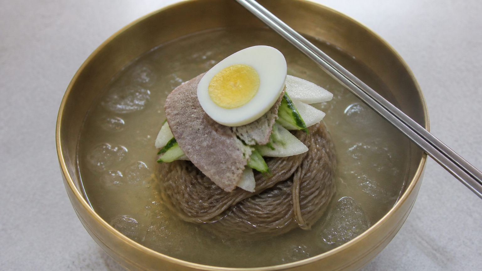 Pyongyang-style naengmyeon in a brass bowl. Illustration by Jeong, Korea
