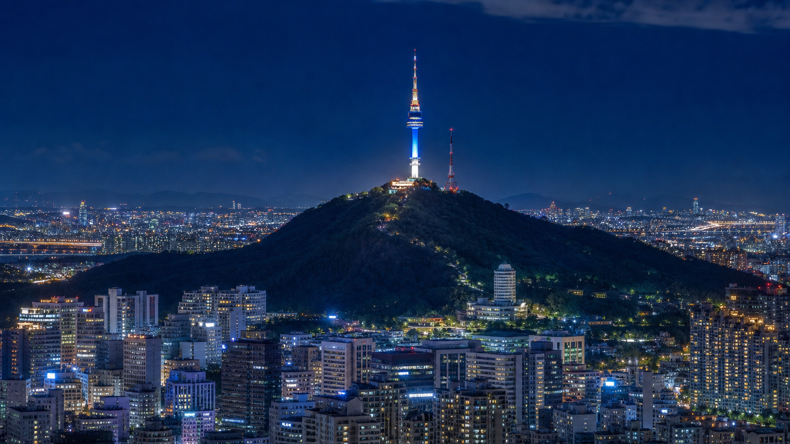 A lit tower on a wooded hill in the middle of the city. Illustration: Jeong, Korea